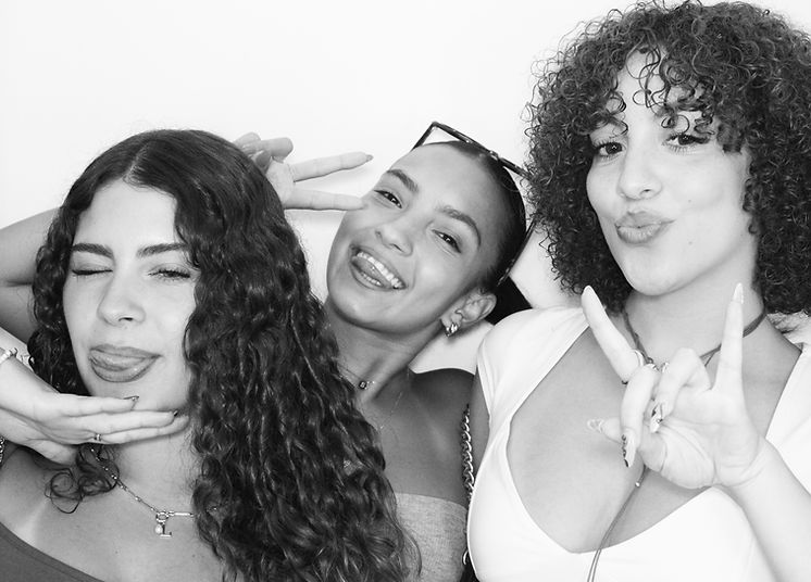 High-end black and white photo of guests inside a private enclosed photo booth, styled with soft lighting and a seamless glam effect.