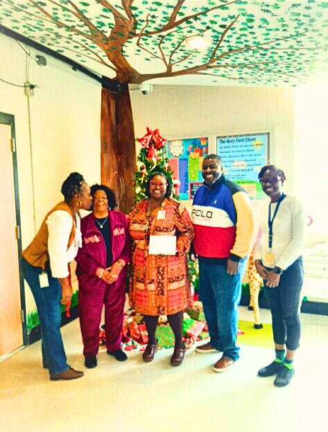 Mrs. Mable Thompson, mother of the late Dailonna Dozier receives a kiss of gratitude for the gift card presented to Mary Ford Early Learning and Family Center in North Charleston, South Carolina. Pictured with the school staff is Jacob Dozier, CEO of DDHF and husband of the late Dailonna Dozier.
