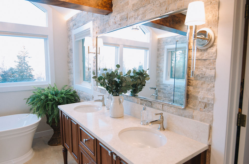 Timeless Tuscan-inspired primary bathroom remodel featuring a freestanding soaking tub, floor-to-ceiling stone walls, exposed wood beam, and custom cherry vanity.