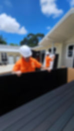 Two workers wearing hard hats installing panels