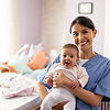 Smiling live-in nanny holding a baby in a nursery