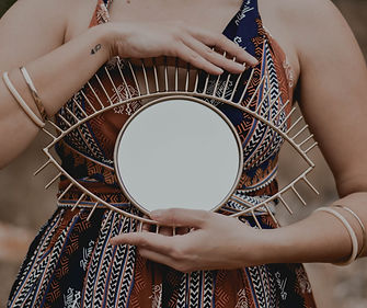 Person holding a round mirror