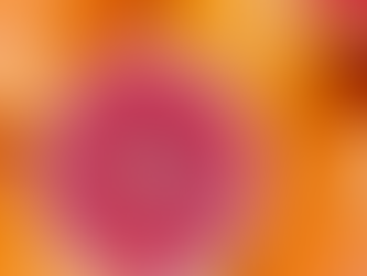Close-up of piled oranges and a halved pink grapefruit, showing bright citrus skins and juicy red flesh.