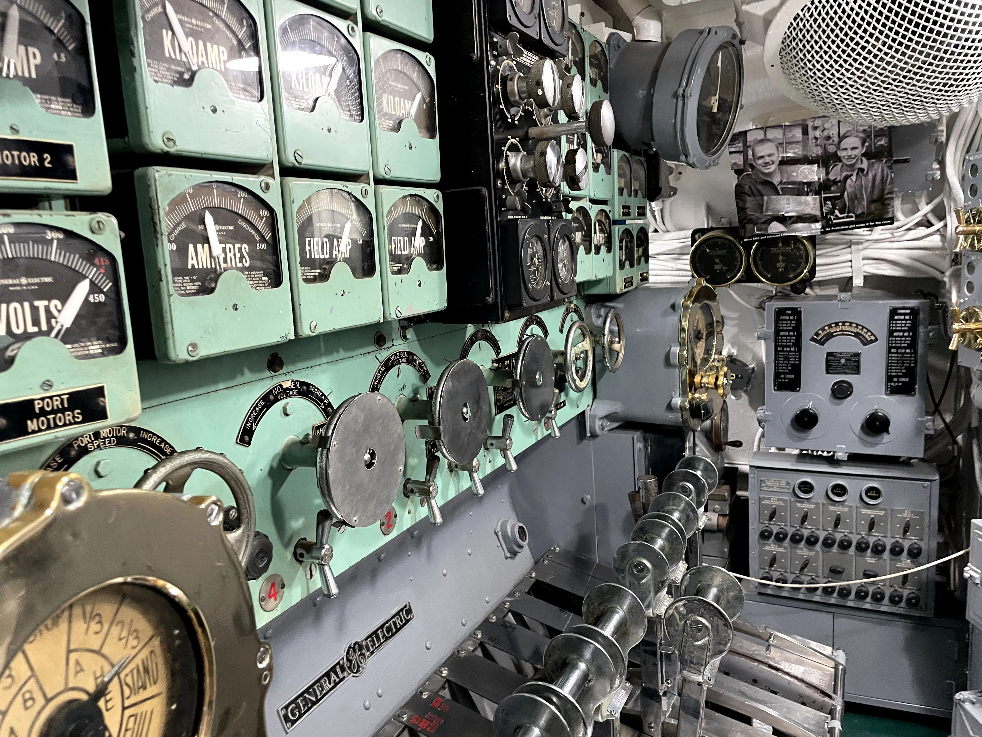Inside a submarine at Pearl Harbor, with teal colored engine. 