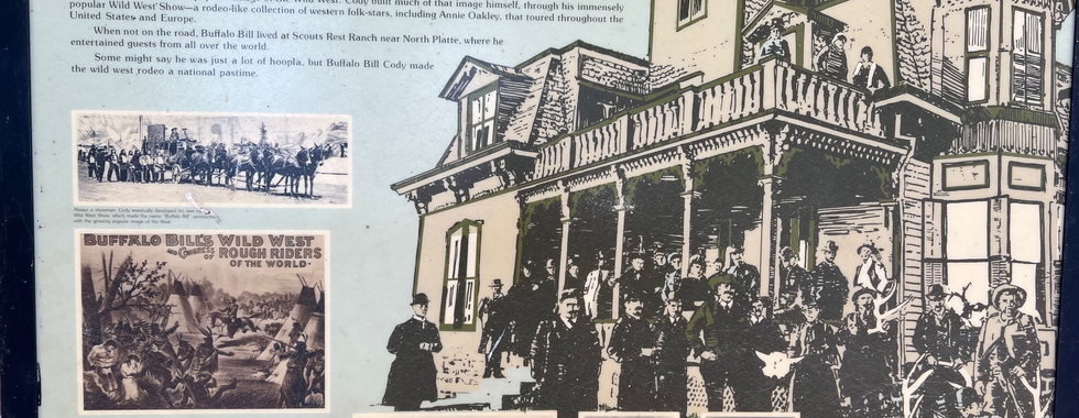 The image is an informational display titled "Home of Buffalo Bill." It features a prominent illustration of a historical building associated with Buffalo Bill, as well as several smaller black-and-white photographs depicting scenes from Buffalo Bill's life and his famous Wild West show.  The main text provides a brief biography of William F. "Buffalo Bill" Cody, highlighting his early life as a Pony Express rider at the age of 15, his military service during the Indian Wars, and his time as a buffalo hunter for the railroads. It emphasizes how Buffalo Bill became a legendary figure embodying the Wild West through his popular Wild West Show—a traveling spectacle that showcased Western folk stories and characters like Annie Oakley, and entertained audiences across the United States and Europe.  The display also notes that when Buffalo Bill was not on the road, he resided at Scouts Rest Ranch near North Platte, where he continued to entertain guests from around the world. It acknowledges that while some contemporaries viewed his Wild West Show as mere entertainment, Buffalo Bill Cody's efforts turned the Wild West rodeo into a national pastime.  The smaller photographs include scenes from Buffalo Bill's Wild West Show, images of the Scouts Rest Ranch, and portraits of Buffalo Bill himself. The captions provide additional context for these images, linking them to significant events and locations in Buffalo Bill's storied life.  Overall, the display serves as a tribute to Buffalo Bill's impact on American culture and his role in popularizing the mythology of the Wild West.
