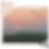 An almost completed jigsaw puzzle showing a serene sunset scene over a field with a line of birds flying across the sky. The