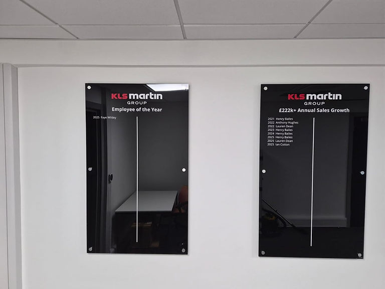 KLS Martin Group acrylic honours boards close-up showing Employee of the Year and Annual Sales Growth panels with white lettering.