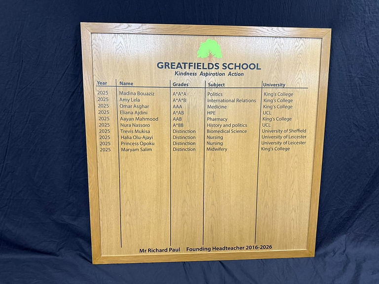 Greatfields School honours board close-up showing engraved school crest, motto, and founding headteacher dedication.