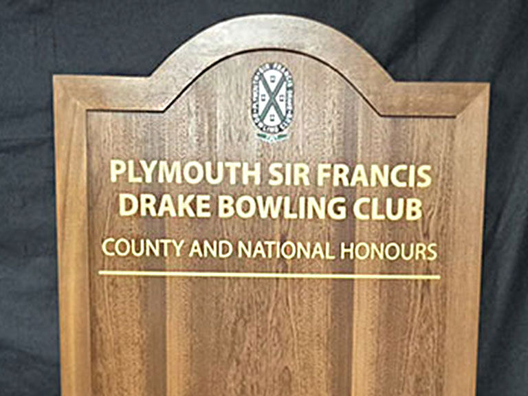 Traditional bowls club honours board showing county and national honours in cream text on dark wood