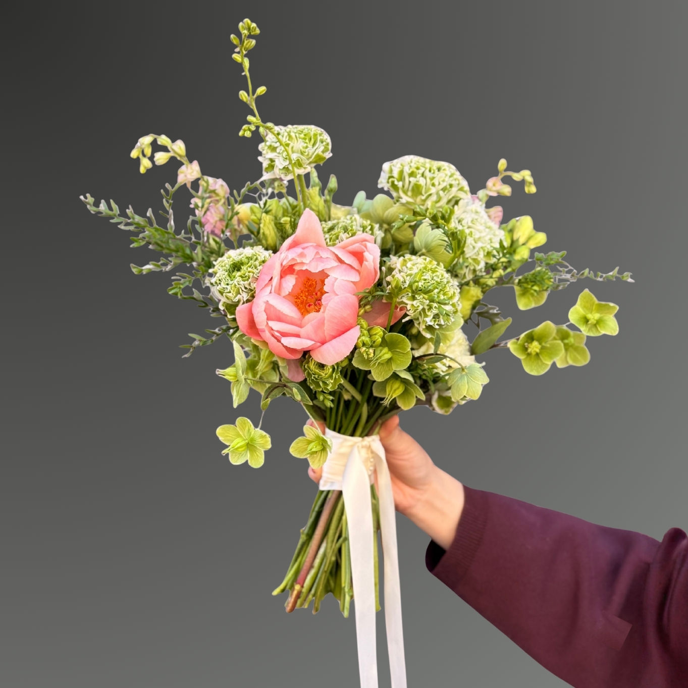 Naturlig brudebuket med grønne blomster og koral pæon i luftig nordisk stil