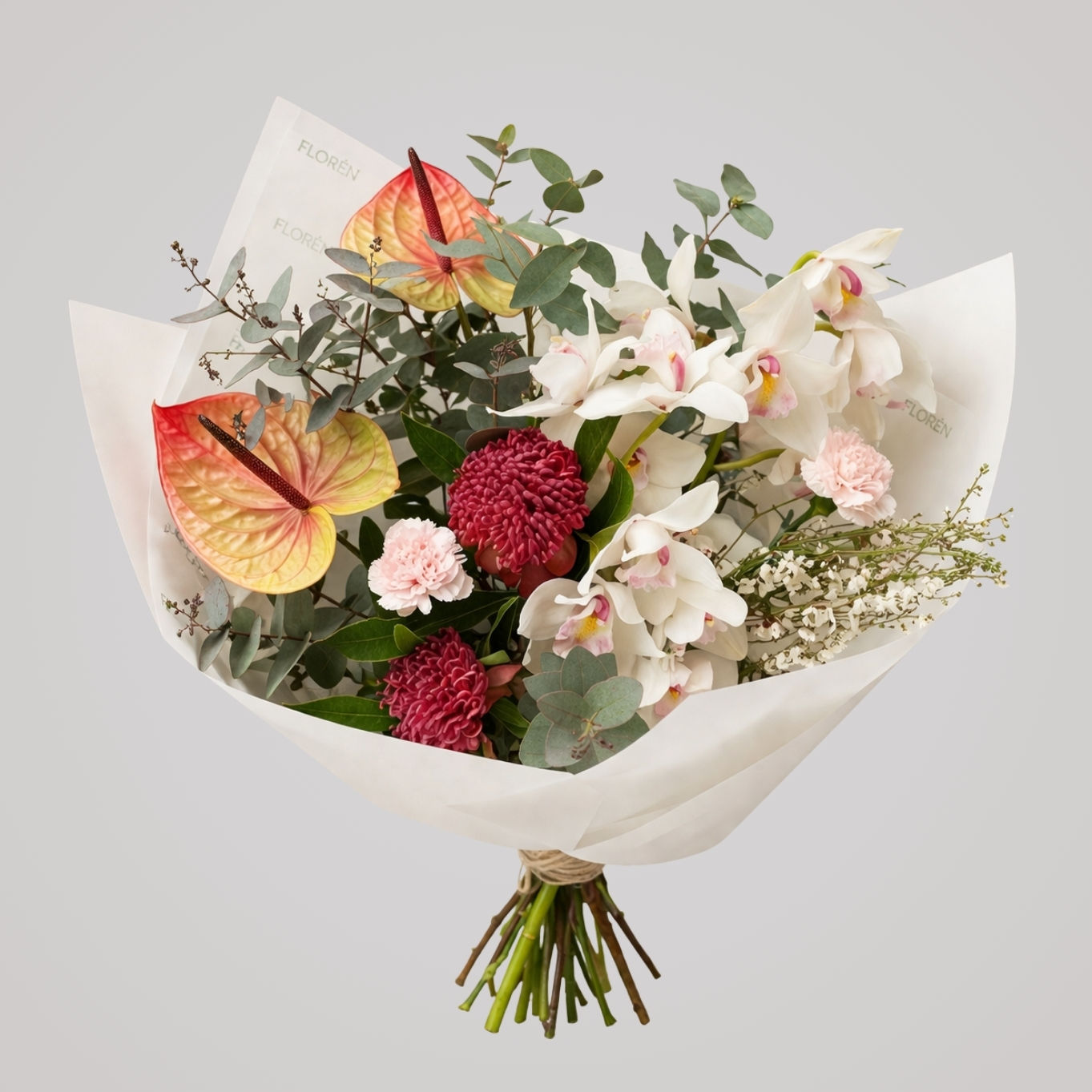 Eksklusiv buket med hvide orkidéer, anthurium og røde blomster i moderne indpakning fra Florén København