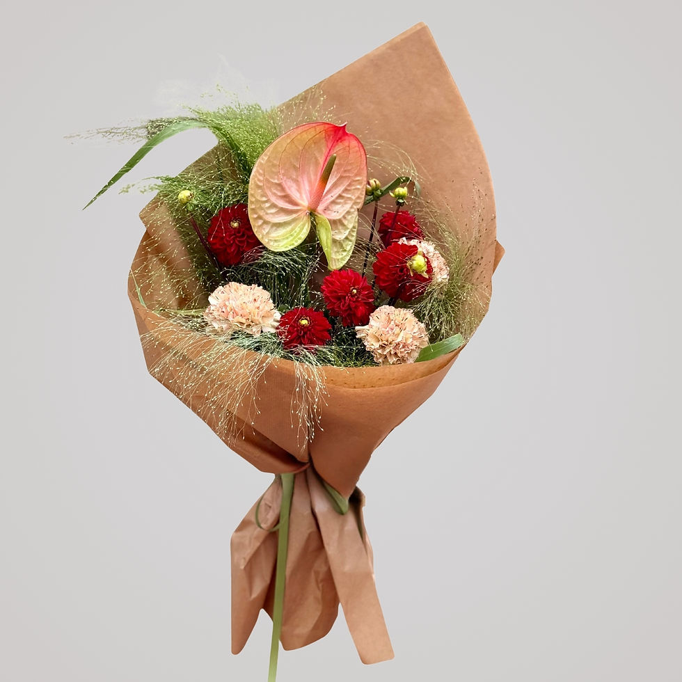 Luksus buket med anthurium, røde georginer, nelliker og luftige prydgræsser håndbundet af Florén i København.