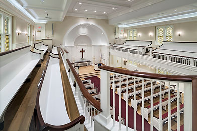 looking down at pew benches from the upper seating area