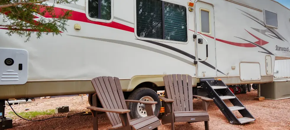 Front of RV rental with two Adirondacks - at Highland Meadows Resort.