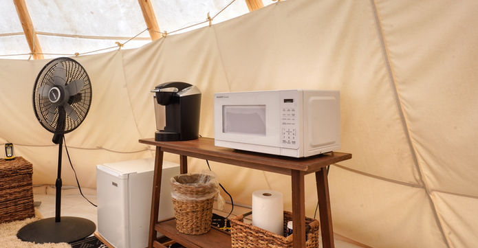 Kitchenette in a glamping teepee complete with Keurig, microwave, and mini fridge.