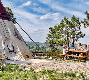 Family having a picnic outside of Buffalo Tipi at HighlandMeadows Resort