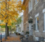The historic brick sidewalk of the Inns at 8th and Main, with fall leaves littered about. 