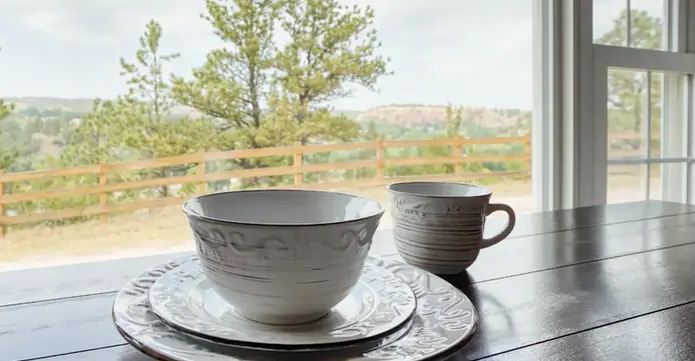 Dishes staged in Columbine Cabin at Highland Meadows Resort. Pine trees in the background.