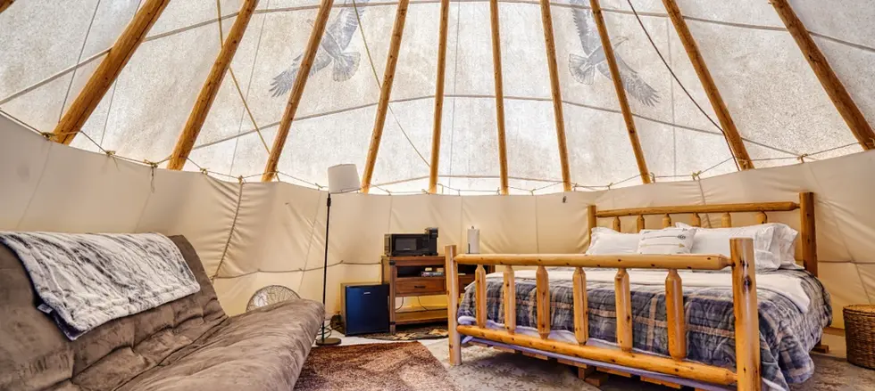 King bed in Black Hills tipi rental - futon and kitchenette.