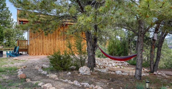 Cabin at Highland Meadows Resort surrounded by pines and a private hammock.
