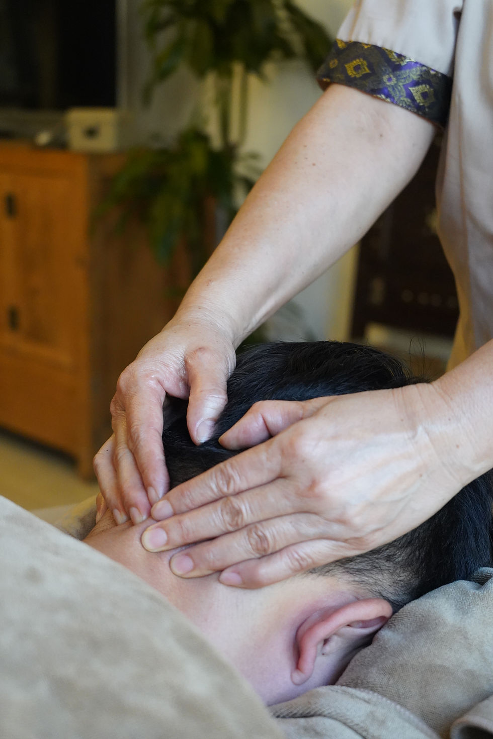 Khlome therapist applying Traditional Thai Herbal Oil during an in-home massage session