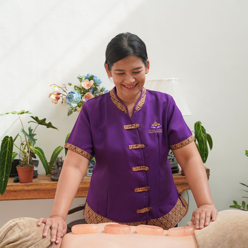Khlome Thai massage therapist preparing premium massage oil, towels, and home spa details for a luxury massage service in Dubai.