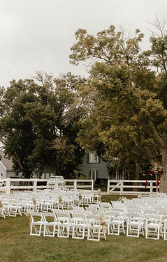 A ceremony set up with white resign chairs.
