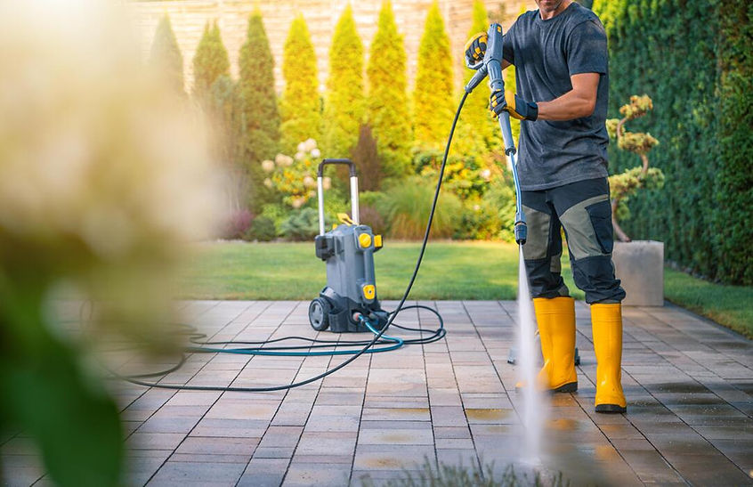 man-using-pressure-washer-to-clean-patio-in-sunny-garden-setting-photo.jpg