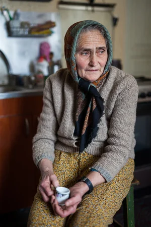 37839980-vieille-femme-roumaine-mouchoir-et-un-cardigan-intérieure.webp