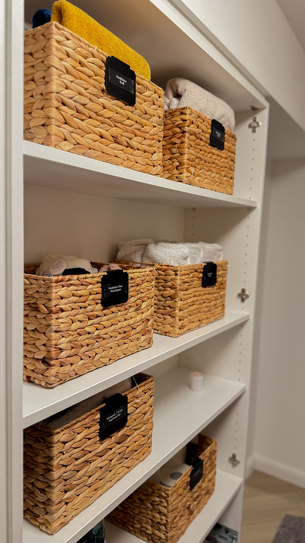 Handtücher ordentlich gefaltet im Badezimmerregal