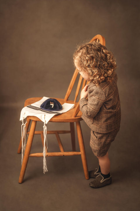 Little boy looking at Yarmulke during Upsherin Photography Session with Chumie Paneth Photography
