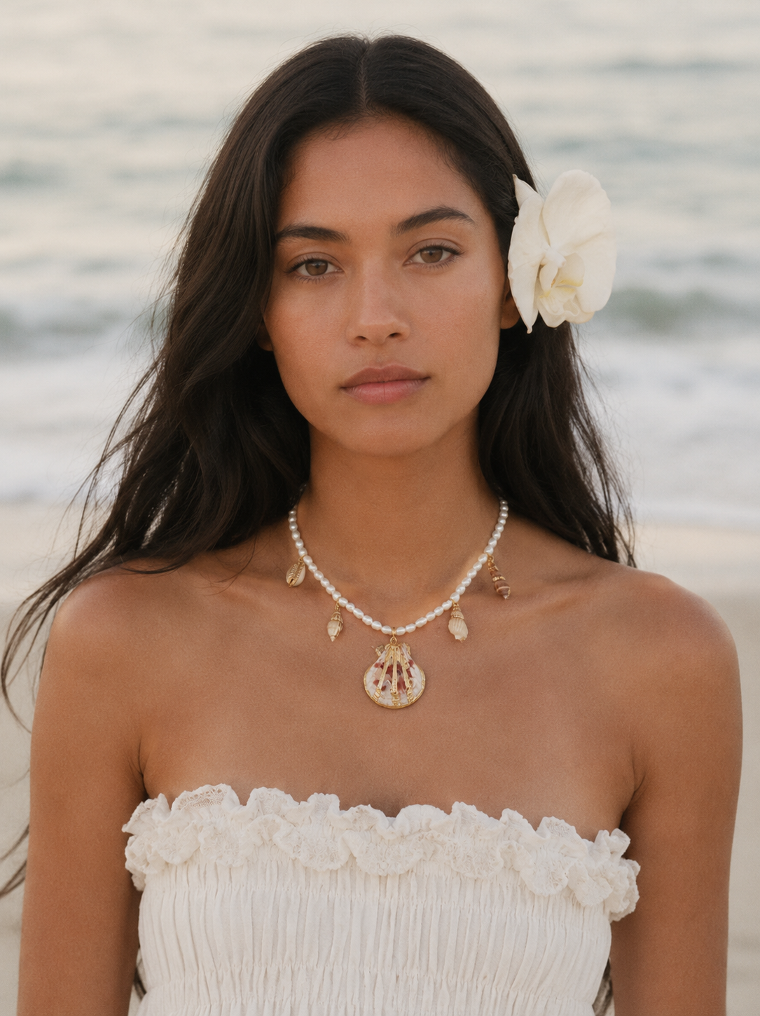 Model wearing the Maris Shell Charm Pearl Necklace, handcrafted with freshwater pearls and a natural shell pendant .