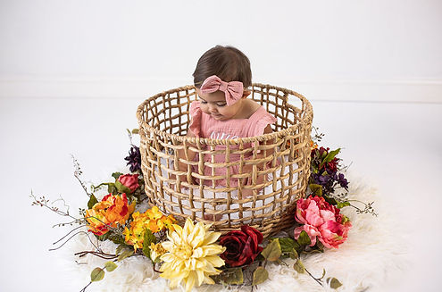 One year old in basket surrounded by flowers in studio in Concord, Ca.
