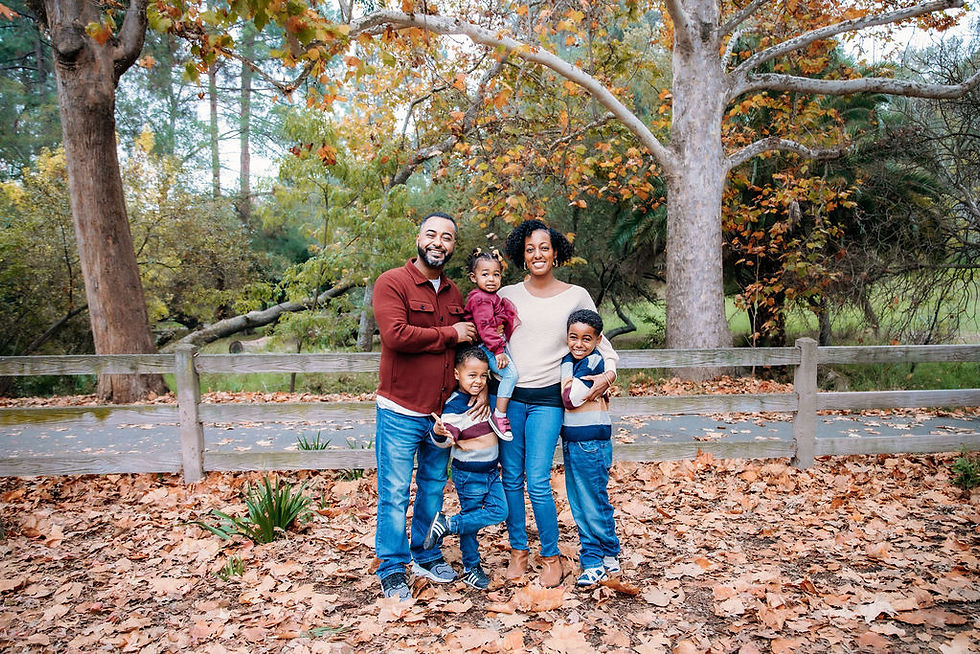 Family of five, well dressed in a fall colored park.
