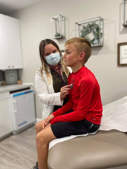 Desireé Samples uses a stethoscope on a younger patient