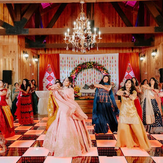 Bridesmaids performing energetic dance routines on a checkered LED floor during Sangeet night in McKinney, Texas.