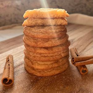 a stack of snickerdoodle cookies next to cinnamon sticks