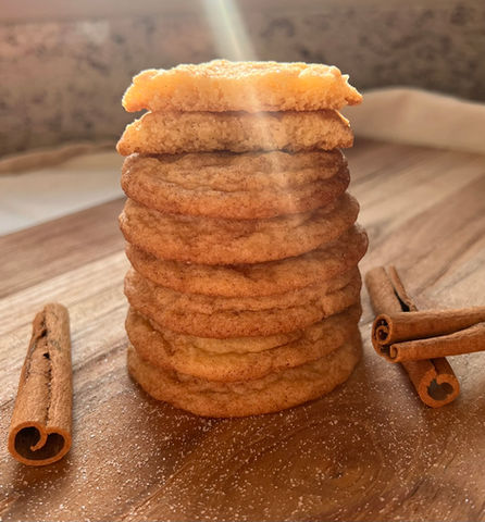 a stack of snickerdoodle cookies next to cinnamon sticks