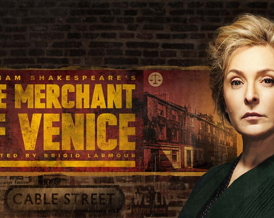 Tracy-Anne Oberman on a brick background with the text THE MERCHANT OF VENICE