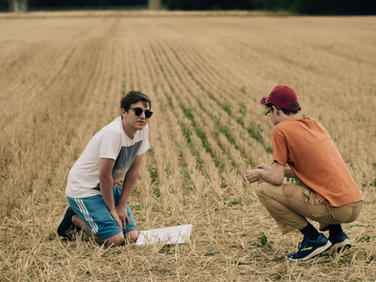Assistant director and script supervisor discussing a script on a film set.