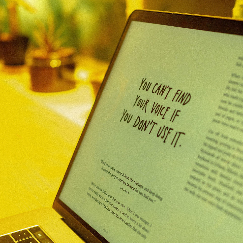 A note that says You can't find your voice if you don't use it, printed on a laptop screen.