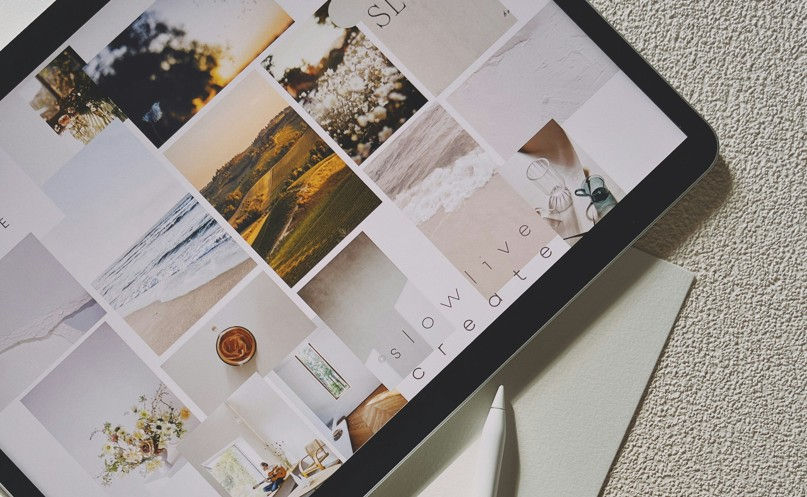 Tablet displaying a collage of serene landscapes and minimal interiors with soft colors. Text says "slow live create." Pen nearby.