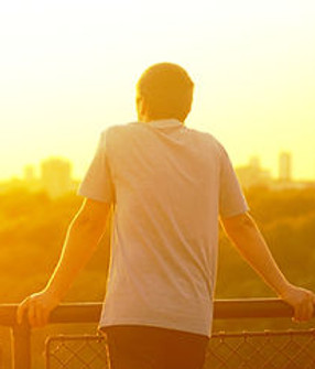 Golden sunset over Belgrade, seen from Kalemegdan fortress A man leans on the railing, wat