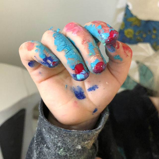 Closeup of toddler fingers covered in paint after an art project.