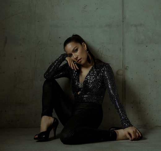 Rachel Hiew, sits seductively on the floor in black leather leggings and high heels
