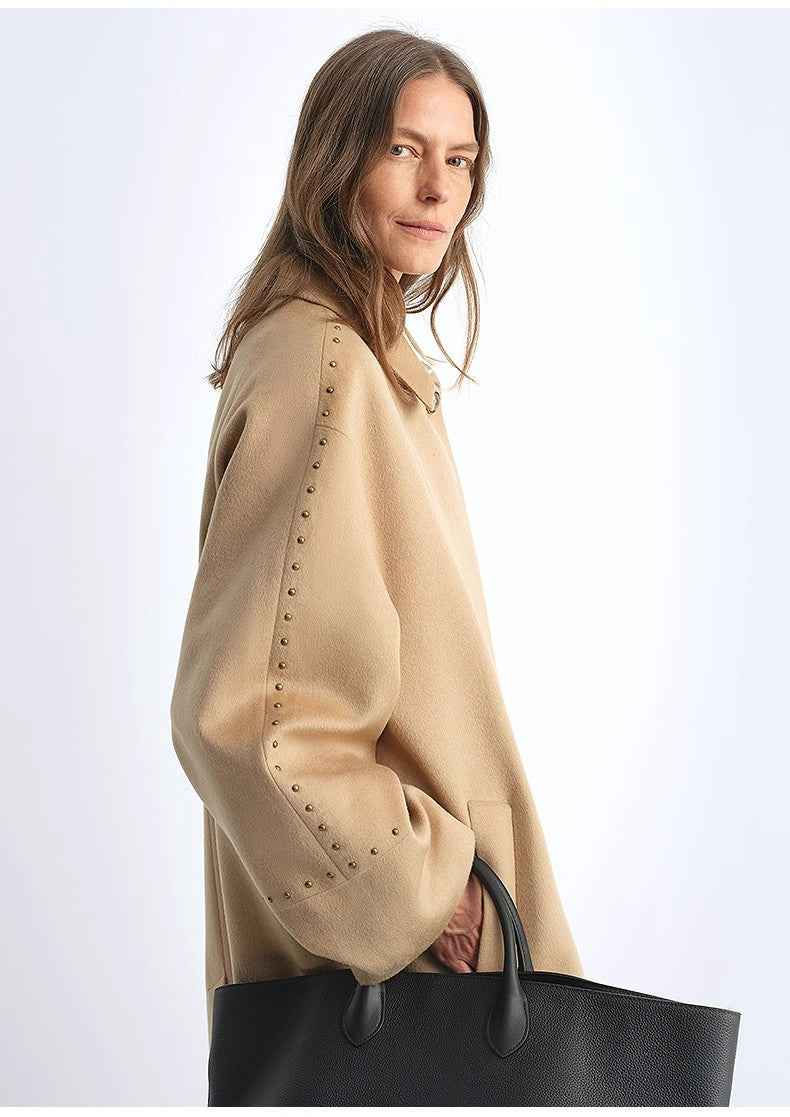 Thumbnail: Woman in light brown coat with studded sleeves