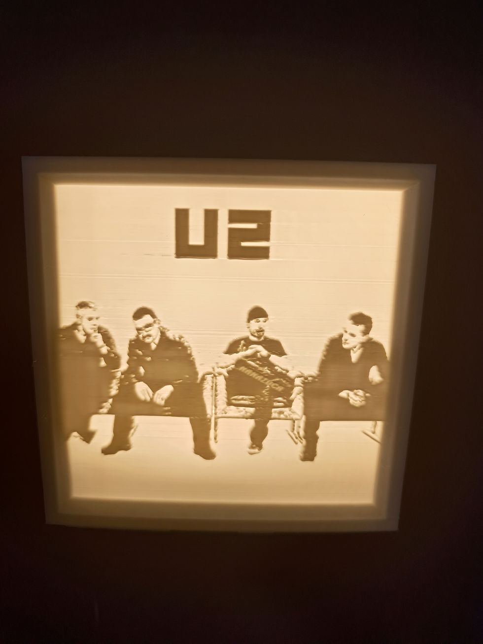 U2 logo and band members in a U2 boîte LED 3D with a warm glow.
