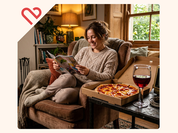 Realistic photography. A woman happily reading a magazine, curled up in a cozy armchair on a relaxing weekend afternoon. Beside her on a clunky, heavy iron side table is a "greedy", massive, extra-cheesy pizza and a hilariously oversized, thick "klinky" glass filled with glowing ruby-red wine. A heavy brass medical stress-monitor sits abandoned and turned off nearby. Funky, dramatic, vibrant living room lighting. Photorealistic real humans, 8k, no text.