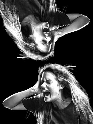 black & white picture of young woman screaming in agony holding right side of her head