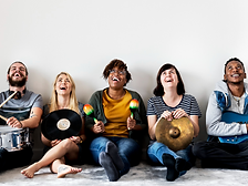 Group of 5 friends sitting enjoying creating music